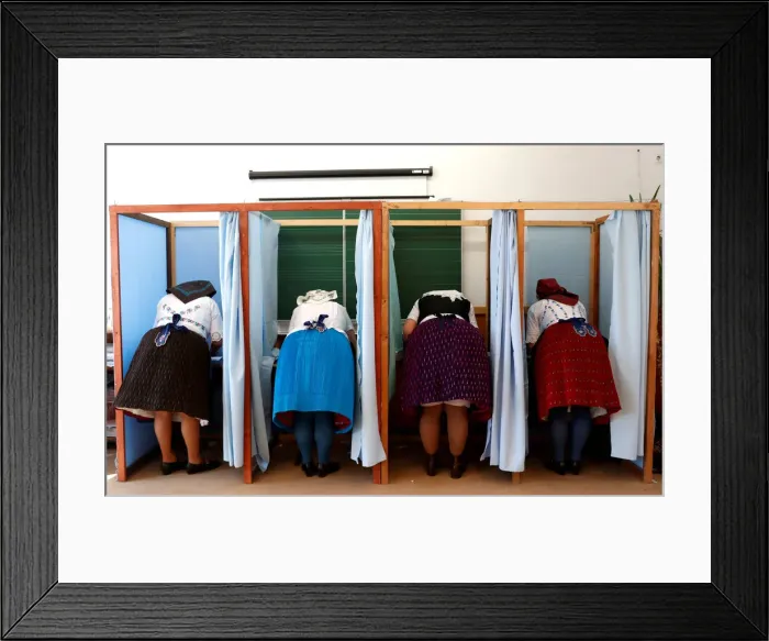 Framed Print : Hungarian women, wearing traditional costumes, fill their ballot papers at a polling