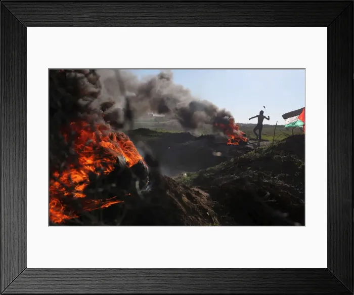 Framed Print : A Palestinian protester uses a sling to hurl stones at Israeli troops during clashes near Framed Print : A Palestinian protester uses a sling to hurl stones at Israeli troops during clashes near