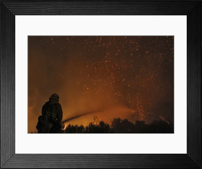 Framed Print : A firefighter douses embers from the Springs Fire at Point Mugu State Park Framed Print : A firefighter douses embers from the Springs Fire at Point Mugu State Park
