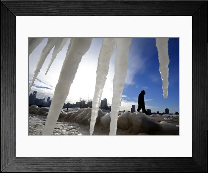 Framed Print : Man is framed by icicles as he walks along a beach in Chicago Framed Print : Man is framed by icicles as he walks along a beach in Chicago