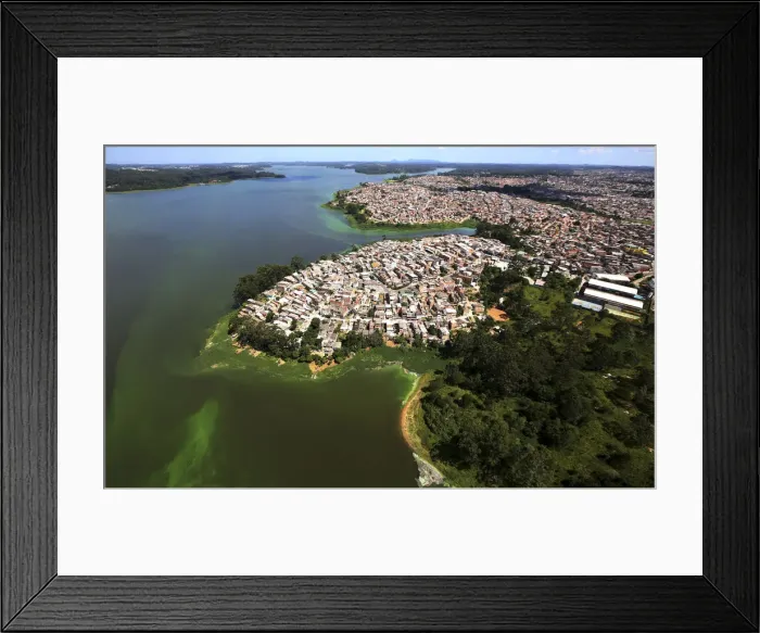 Framed Print : An aerial view of shows illegally built slums on the border of the polluted water of Framed Print : An aerial view of shows illegally built slums on the border of the polluted water of