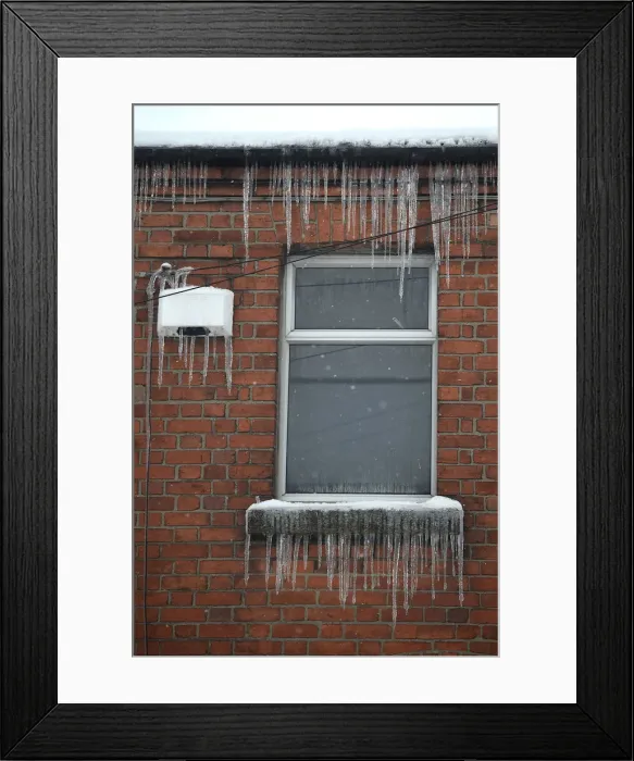 Framed Print : Icicles are seen hanging from a window and house alarm during snow fall in Dublin Framed Print : Icicles are seen hanging from a window and house alarm during snow fall in Dublin