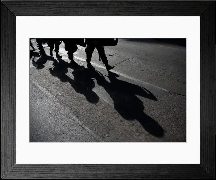 Framed Print : Military policemen cast their shadows as they march toward a protest to mark