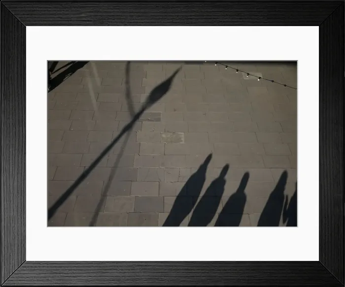 Framed Print : The shadows of pedestrians are cast on the pavement as they walk along the South Bank in Framed Print : The shadows of pedestrians are cast on the pavement as they walk along the South Bank in