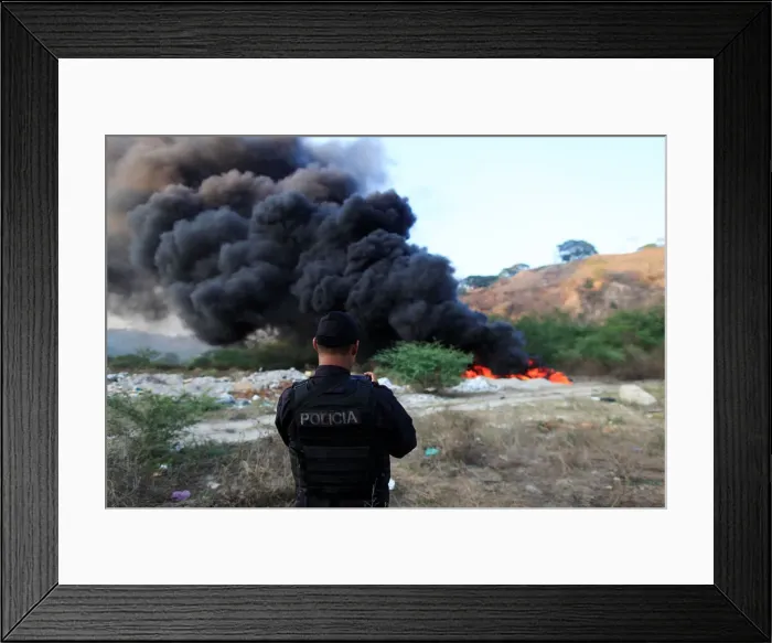 Framed Print : A police officer takes a picture during the incineration of seized cocaine in Ilopango Framed Print : A police officer takes a picture during the incineration of seized cocaine in Ilopango