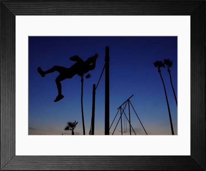 Framed Print : A man works in his high bar skills at sunset in the Venice Beach area of Los Angeles Framed Print : A man works in his high bar skills at sunset in the Venice Beach area of Los Angeles