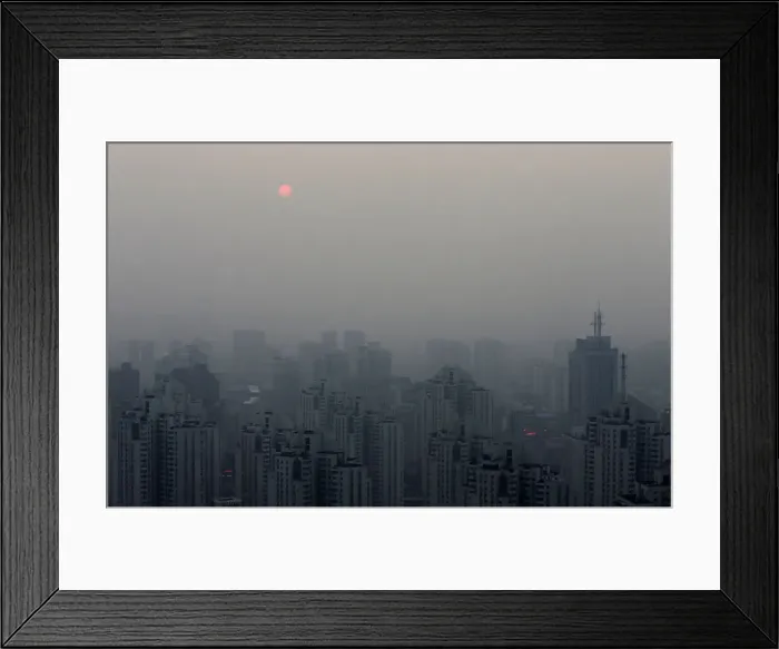 Framed Print : The sun sets above residential buildings on a hazy day in Beijing Framed Print : The sun sets above residential buildings on a hazy day in Beijing