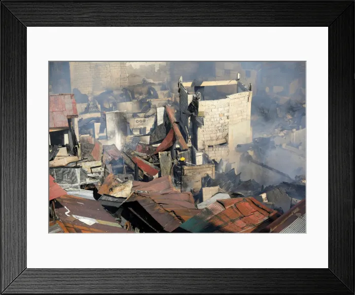 Framed Print : A fireman fights fire at shanties in a residential area near the Malacanang presidential Framed Print : A fireman fights fire at shanties in a residential area near the Malacanang presidential