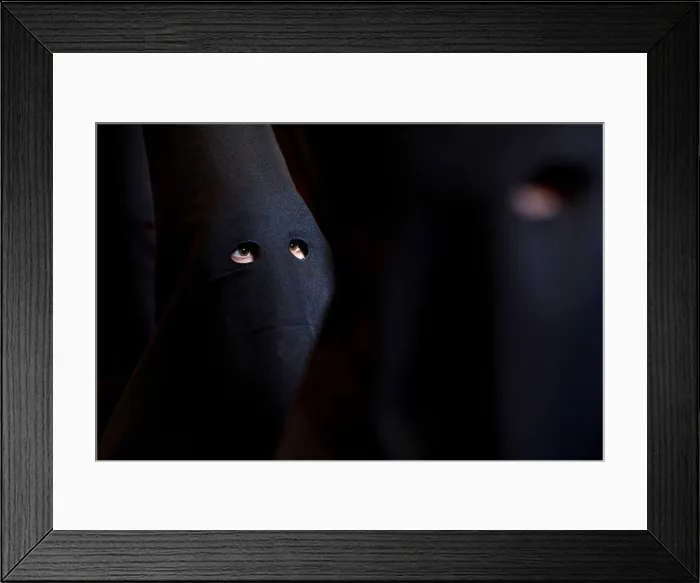 Framed Print : Penitents of Los Estudiantes brotherhood wait for the start of the procession during