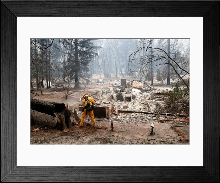 Framed Print : A firefighter extinguishes a hot spot in a neighbourhood destroyed by the Camp Fire in Framed Print : A firefighter extinguishes a hot spot in a neighbourhood destroyed by the Camp Fire in