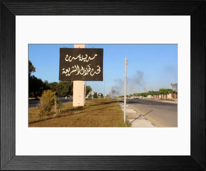 Framed Print : Still image of an Arabic sign with smoke rising in background as forces aligned with Framed Print : Still image of an Arabic sign with smoke rising in background as forces aligned with