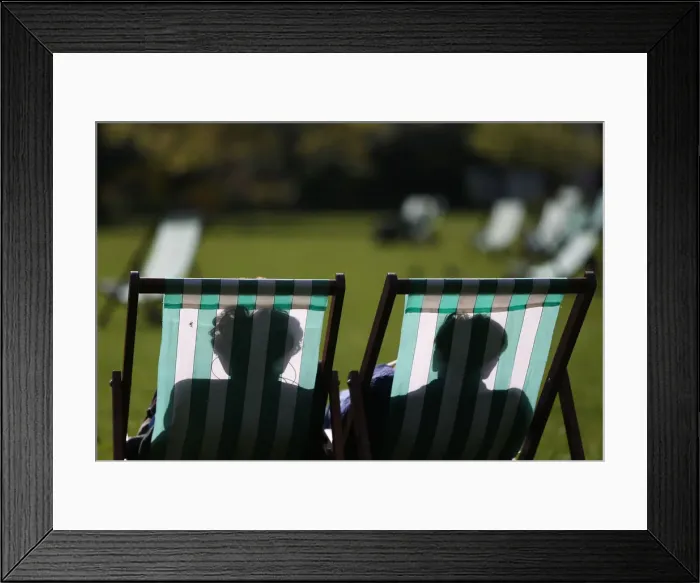 Framed Print : People relax on deck chairs on a warm day in London, Britain Framed Print : People relax on deck chairs on a warm day in London, Britain