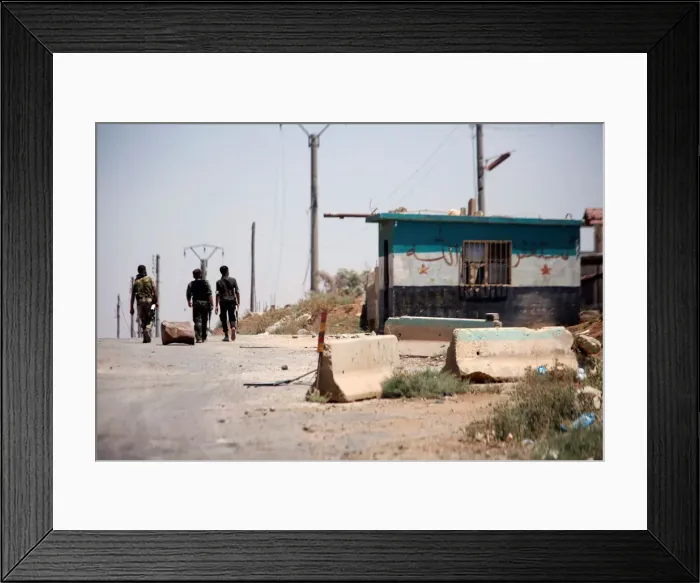 Framed Print : Syrian army soldiers walk along a street in Umm al-Mayazen, in the countryside of Deraa
