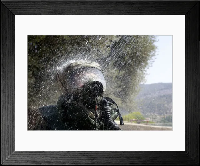 Framed Print : An Israeli soldier wearing a protective gear is sprayed with water during a drill Framed Print : An Israeli soldier wearing a protective gear is sprayed with water during a drill