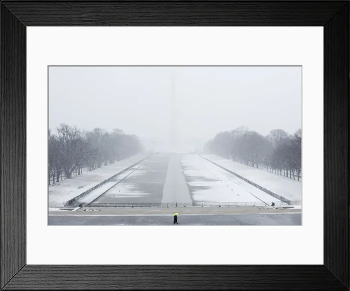 Framed Print : A lone tourist walks on the National Mall near the Lincoln Memorial during a snow storm Framed Print : A lone tourist walks on the National Mall near the Lincoln Memorial during a snow storm
