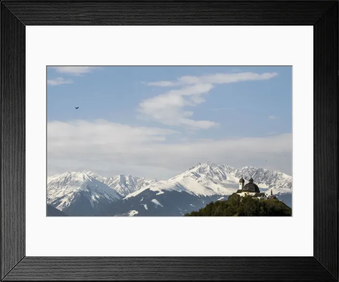 Framed Print : A chapel is seen on a sunny autumn day in front of snow covered mountains in the wetsern