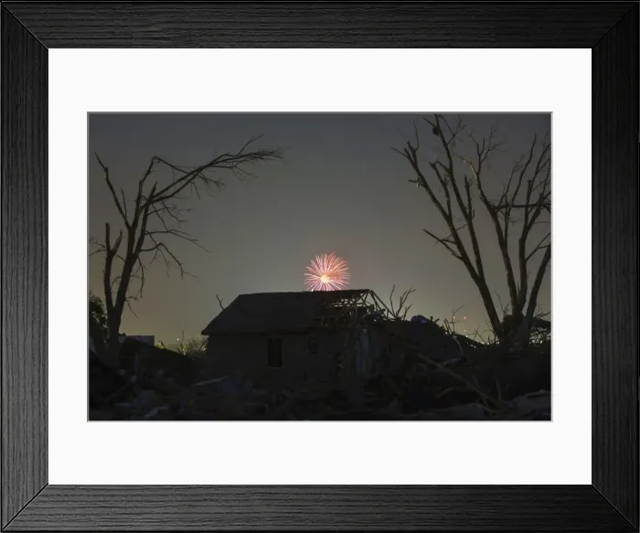 Framed Print : Memorial Day fireworks explode over a house damaged by the May 20 afternoon tornado in