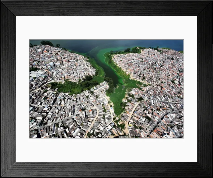 Framed Print : An aerial view shows illegally built slums on the border of the polluted water of Framed Print : An aerial view shows illegally built slums on the border of the polluted water of