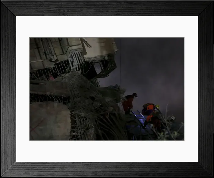 Framed Print : Rescue personnel search the debris of a 17-storey apartment building that collapsed after