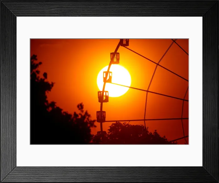 Framed Print : The sun is seen through the giant Ferris wheel at Place de la Concorde at sunset in Paris