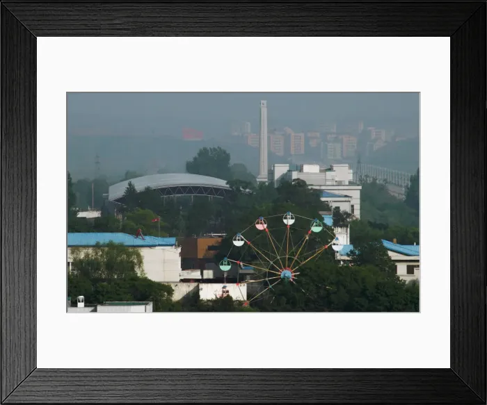 Framed Print : A ferris wheel is seen in the North Korean town of Sinuiju from the Chinese side of