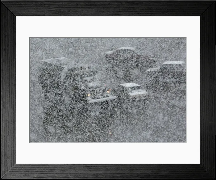 Framed Print : Vehicles drive along a road during a heavy snowfall in the Siberian town of Divnogorsk Framed Print : Vehicles drive along a road during a heavy snowfall in the Siberian town of Divnogorsk