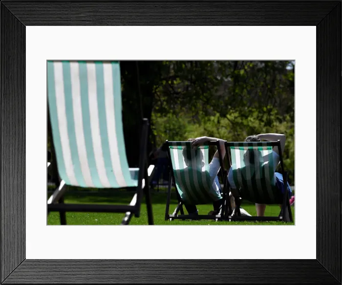 Framed Print : People are silhouetted against the farbric of deckchairs as they enjoy the sunshine in St Framed Print : People are silhouetted against the farbric of deckchairs as they enjoy the sunshine in St