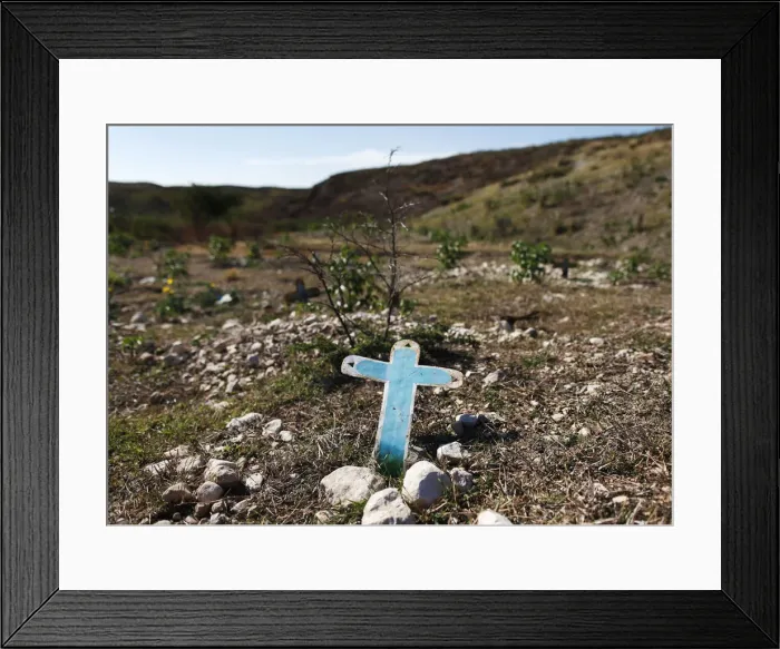 Framed Print : A cross is seen at a burial site for those who died of the cholera epidemic on