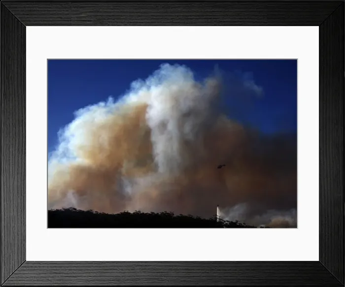 Framed Print : A helicopter drops water on a bushfire approaching homes near the Blue Mountains suburb Framed Print : A helicopter drops water on a bushfire approaching homes near the Blue Mountains suburb
