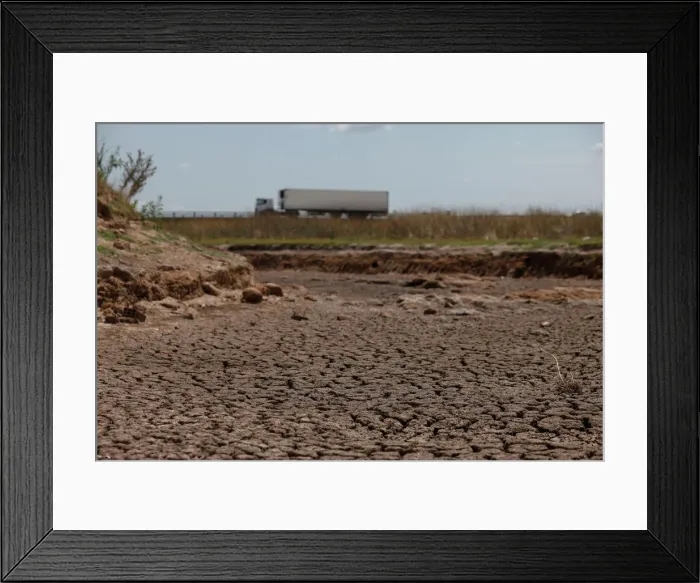 Framed Print : A truck passes by a dried-up creek bed in a drought-affected area near Chivilcoy