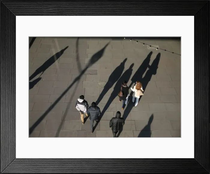 Framed Print : The shadows of pedestrians are cast on the pavement as they walk along the South Bank in Framed Print : The shadows of pedestrians are cast on the pavement as they walk along the South Bank in