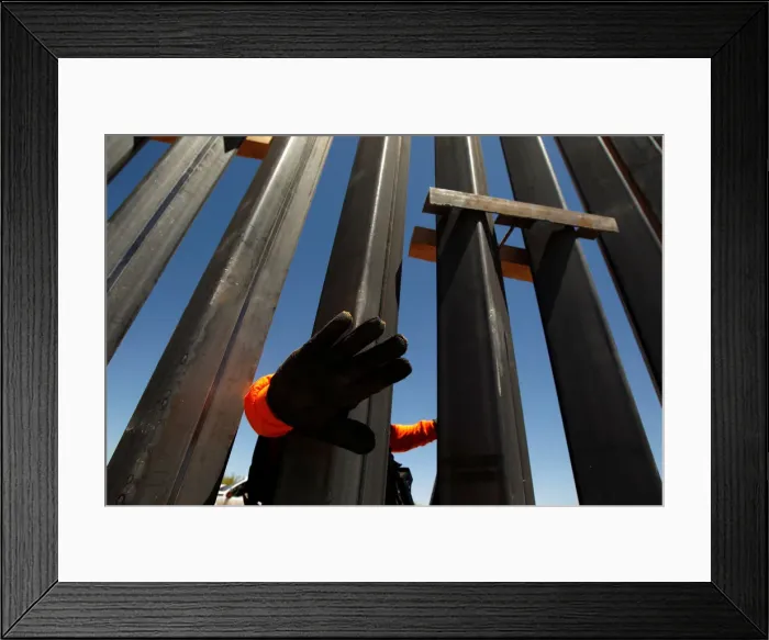 Framed Print : A private security guard blocks the camera to avoid being photographed at a new section Framed Print : A private security guard blocks the camera to avoid being photographed at a new section