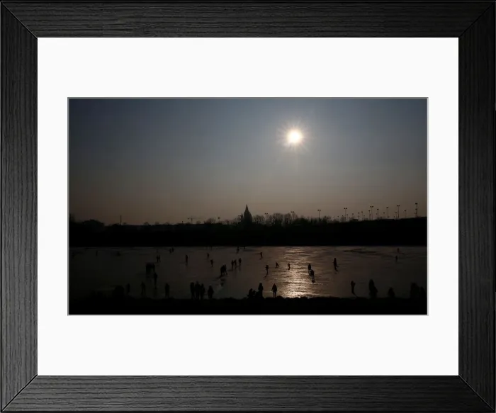 Framed Print : People enjoy a sunny winter day on the frozen New Danube river in Vienna
