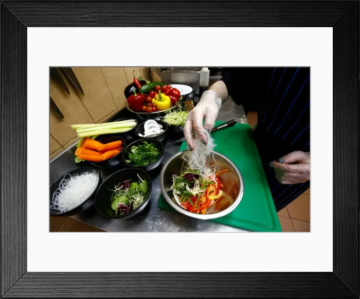 Framed Print : Employee prepares a salad in vegetarian restaurant Green Cuisine in Minsk