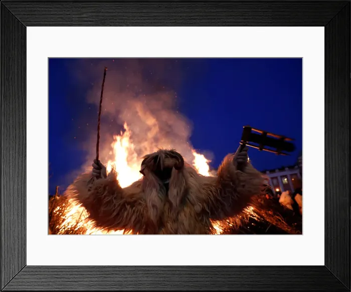 Framed Print : A reveller wearing a mask dances near a bonfire during the traditional Buso Carnival in Framed Print : A reveller wearing a mask dances near a bonfire during the traditional Buso Carnival in