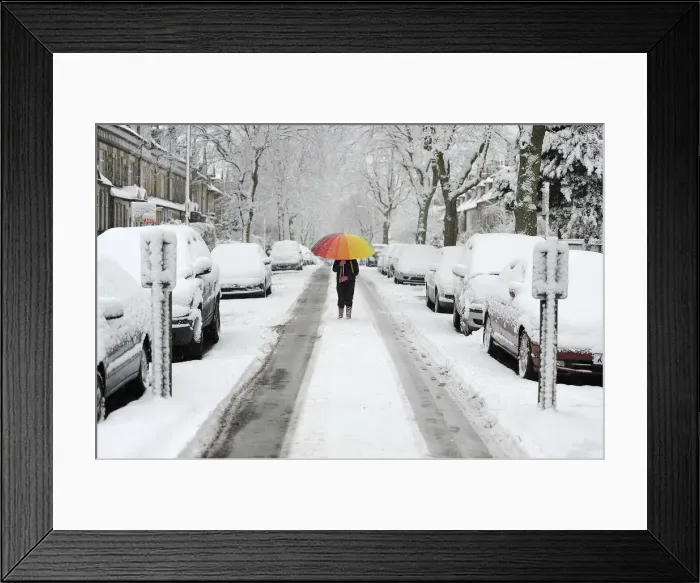 Framed Print : A girl walks along a snow covered street in Knaresborough