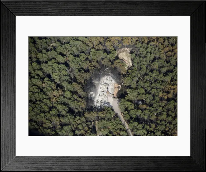 Framed Print : An aerial view of a destroyed house surrounded by dense forest in the aftermath of Framed Print : An aerial view of a destroyed house surrounded by dense forest in the aftermath of