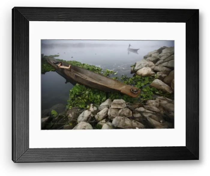 Framed Print : A man pushes his boat with the help of a bamboo stick to reach the bank of Rapti River Framed Print : A man pushes his boat with the help of a bamboo stick to reach the bank of Rapti River