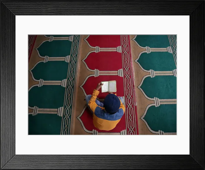 Framed Print : A Muslim man reads the Koran inside a mosque during the holy month of Ramadan in Framed Print : A Muslim man reads the Koran inside a mosque during the holy month of Ramadan in