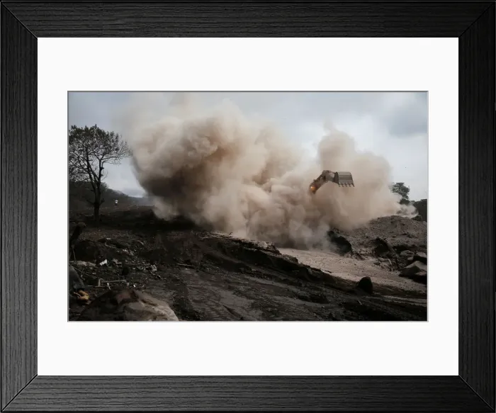 Framed Print : An excavator removes ash from an area affected by the eruption of Fuego volcano in San Framed Print : An excavator removes ash from an area affected by the eruption of Fuego volcano in San