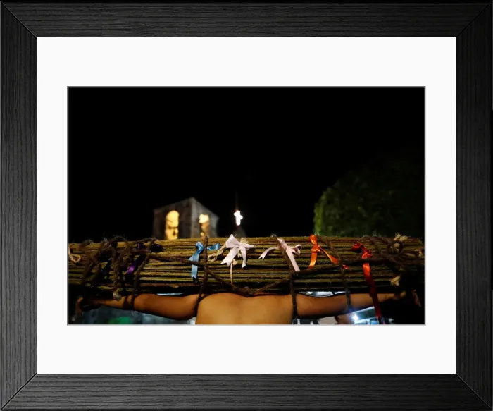 Framed Print : A masked penitent carries thorny boughs with ribbons on his shoulders during a procession Framed Print : A masked penitent carries thorny boughs with ribbons on his shoulders during a procession