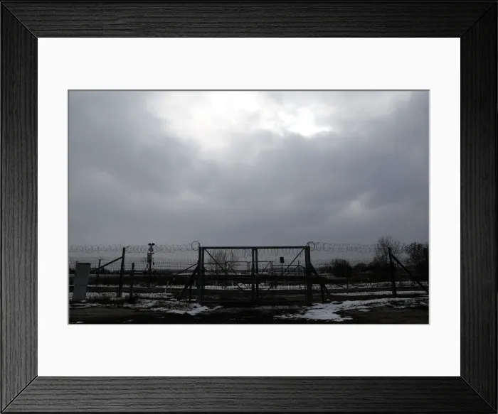 Framed Print : A wire fence is seen next to the village of Asotthalom Framed Print : A wire fence is seen next to the village of Asotthalom