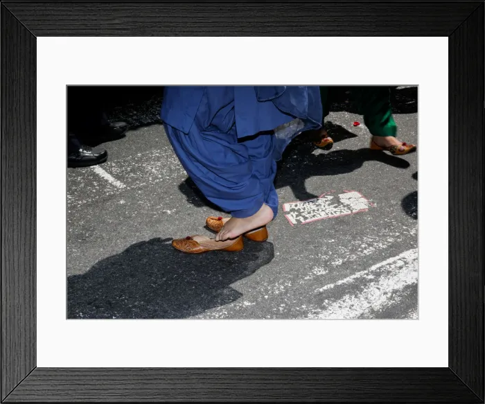 Framed Print : A participant puts her shoes on after taking them off to do an offering at the Annual Framed Print : A participant puts her shoes on after taking them off to do an offering at the Annual