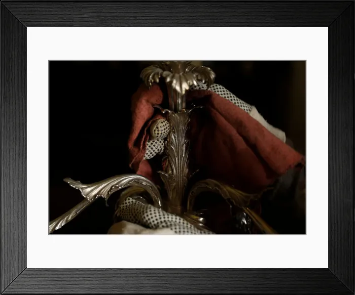 Framed Print : A woman polishes an antique silver candelabra at her home in Valletta