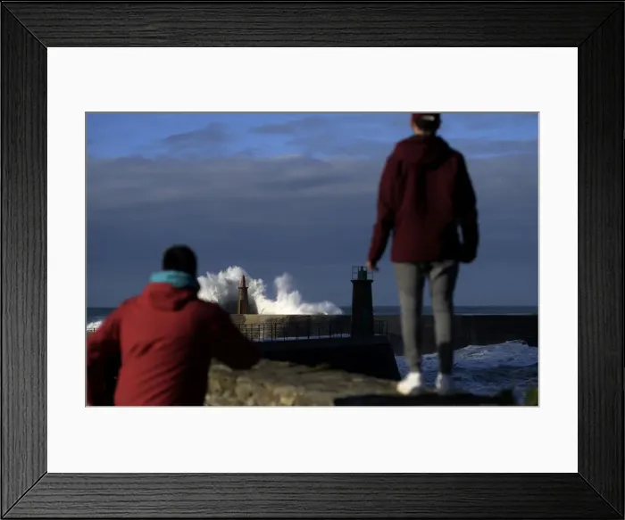 Framed Print : Two boys look at waves as they crash against a lighthouse in the port town of Viavelez Framed Print : Two boys look at waves as they crash against a lighthouse in the port town of Viavelez