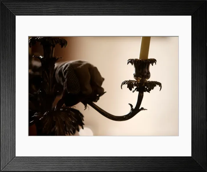 Framed Print : A woman polishes an antique silver candelabra at her home in Valletta