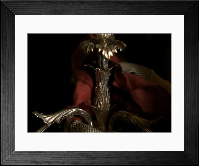 Framed Print : A woman polishes an antique silver candelabra at her home in Valletta
