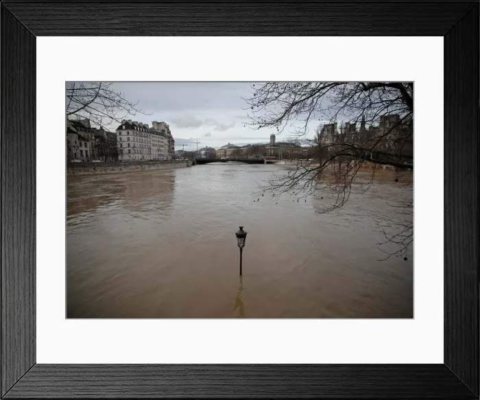 Framed Print : A street-lamp is seen on the flooded banks of the Seine River in Paris Framed Print : A street-lamp is seen on the flooded banks of the Seine River in Paris