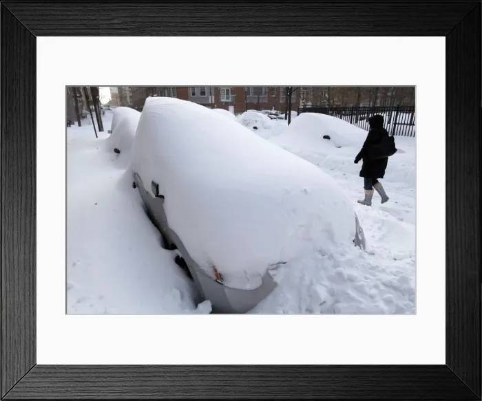 Framed Print : A woman walks past a row of cars buried in the snow in Hoboken Framed Print : A woman walks past a row of cars buried in the snow in Hoboken