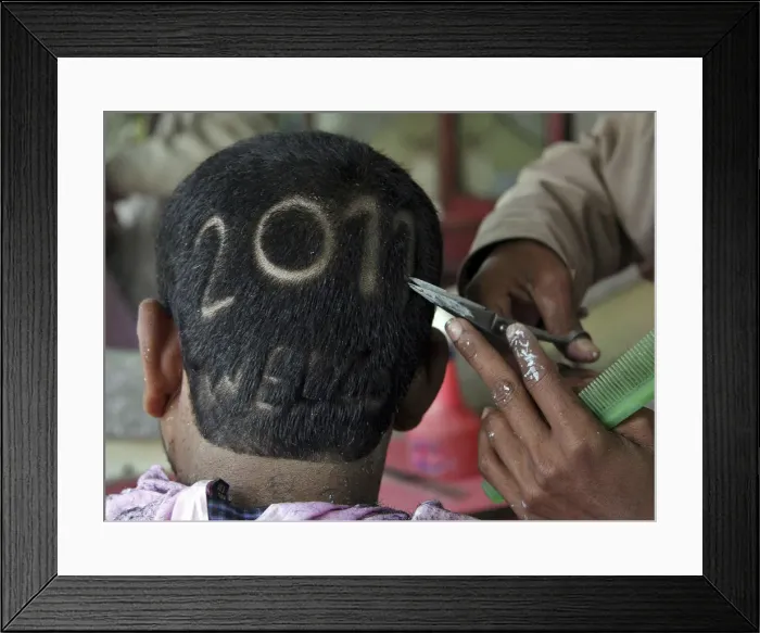 Framed Print : A man gets a haircut depicting 2011 to welcome the new year at a barbershop in